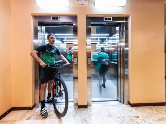 Hombre en bici saliendo del ascensor Orona