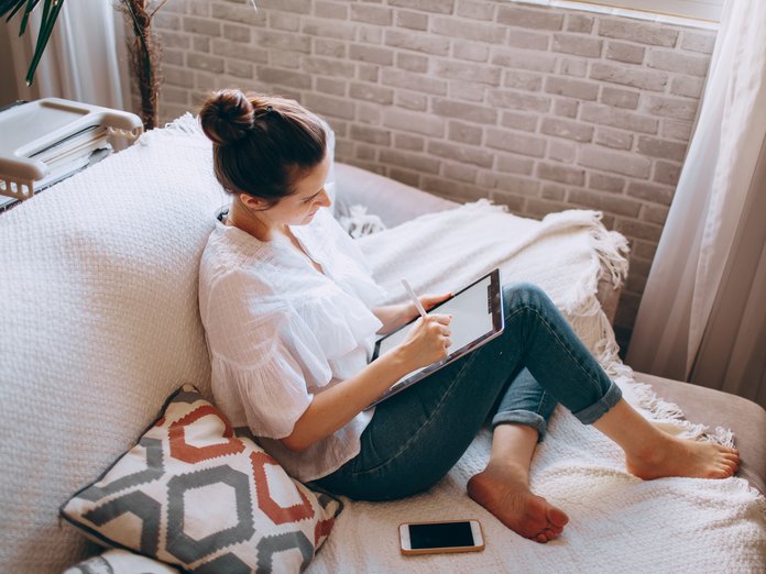 vrouw op een bank die op internet surft met een iPad