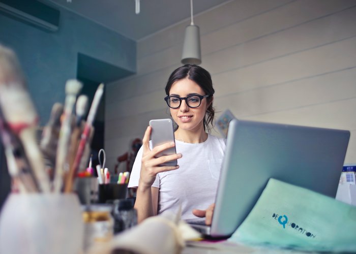 Jonge vrouw die iets regelt via haar mobiele telefoon