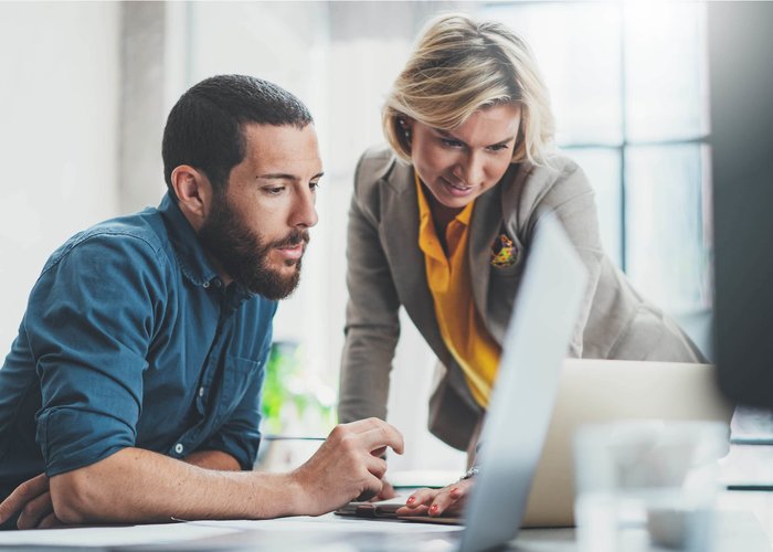 man en vrouw die achter de computer werken